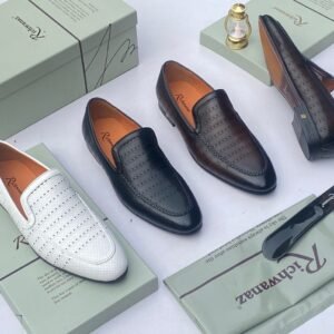 A pair of white leather loafers with perforations, displayed on a shoe box with a luxurious background, showcasing the shoe's intricate details and craftsmanship.