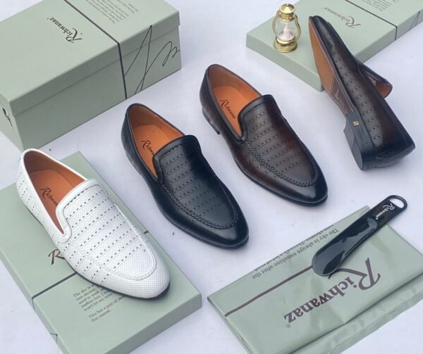 A pair of white leather loafers with perforations, displayed on a shoe box with a luxurious background, showcasing the shoe's intricate details and craftsmanship.