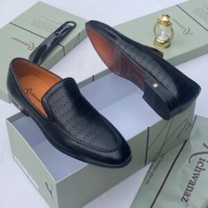 A pair of white leather loafers with perforations, displayed on a shoe box with a luxurious background, showcasing the shoe's intricate details and craftsmanship.