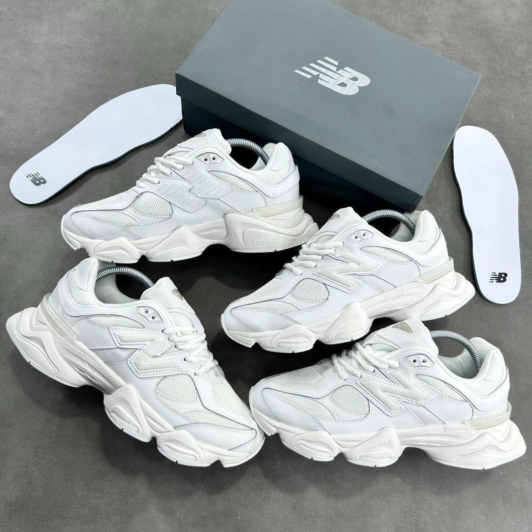 Luxurious all-white New Balance sneakers with sleek design and premium materials, presented with box and insoles.