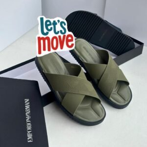 A pair of beige and black Emporio Armani inspired double strap slides on a beige surface with Emporio Armani boxes in the background.