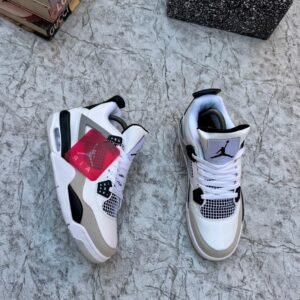 A pair of luxurious white and grey Air Jordan 4 sneakers on a marble surface, exuding high-end style and sophistication.