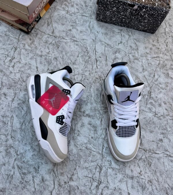 A pair of luxurious white and grey Air Jordan 4 sneakers on a marble surface, exuding high-end style and sophistication.