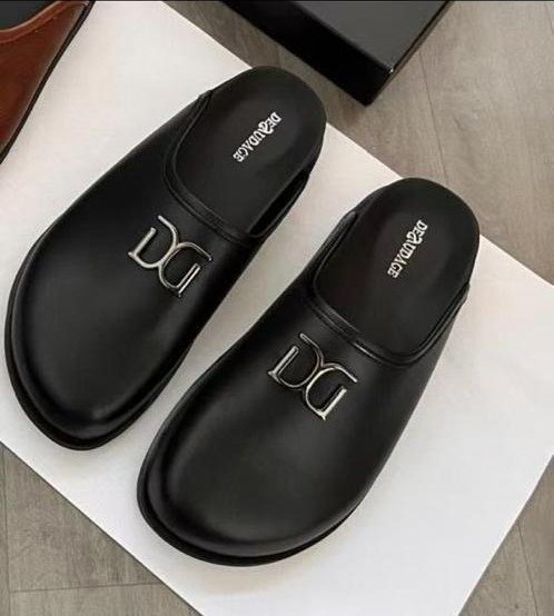 A pair of black leather DG logo slip-on sandals on a white background, perfect for stylish and comfortable footwear.