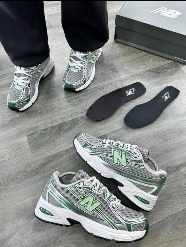 root Grey and green New Balance 530 running shoes on a wooden floor with box and insoles, perfect for men looking for comfort and style.