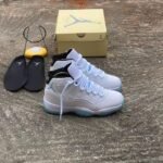 A pair of white and blue Air Jordan 11 sneakers with a yellow shoe box and black slippers on a concrete floor, perfect for sneaker enthusiasts in Nigeria.