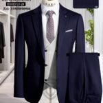A navy blue pinstripe suit with a white vest and patterned tie on a mannequin, showcasing a stylish and formal outfit.