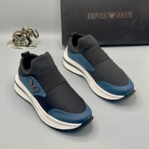 A pair of black and blue Emporio Armani sneakers with a white sole, displayed with a black box and a silver elephant figurine.