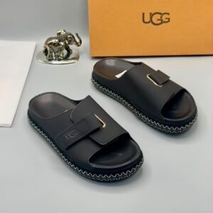 Grey UGG slide sandals with gold buckle and stitched sole, perfect for comfortable and stylish wear.
