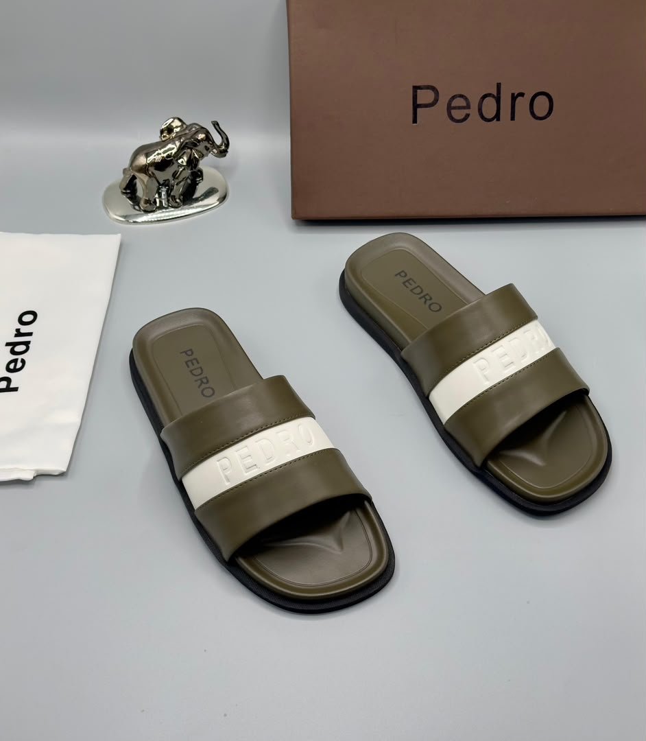 A pair of stylish brown slides with navy blue and white stripes, accompanied by a brown shoe box and accessories, all bearing the 'Pedro' brand name.