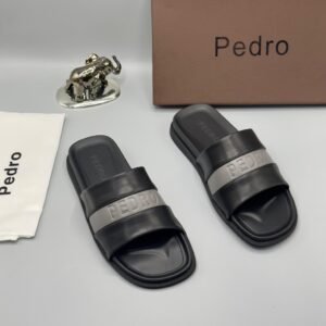 A pair of stylish brown slides with navy blue and white stripes, accompanied by a brown shoe box and accessories, all bearing the 'Pedro' brand name.